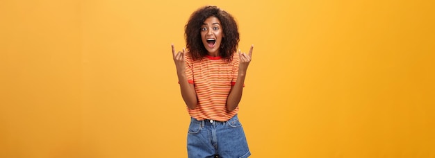 Stylish african american woman being delighted and excited before cool concert showing rock n roll