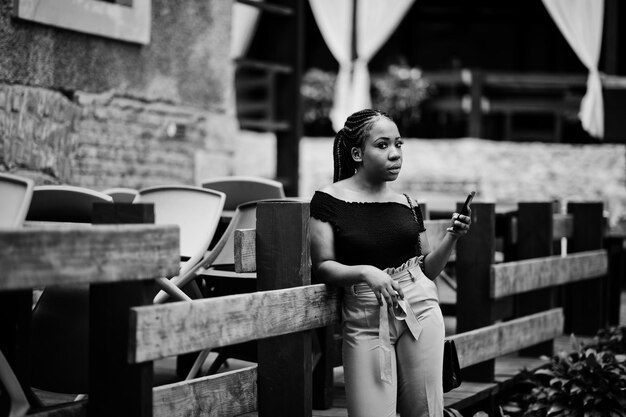 Stylish african american woman posed outdoor and using mobile phone