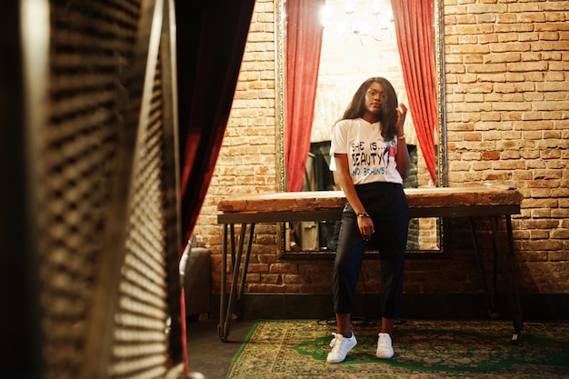 Stylish african american woman in printed tshirt posed indoor