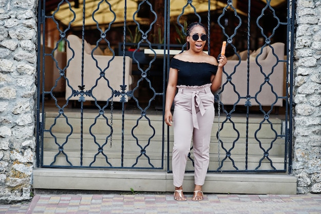 Stylish african american woman at sunglasses with ice cream