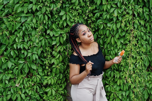 Elegante donna afroamericana in occhiali da sole con gelato