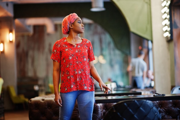 Free photo stylish african woman in red shirt and hat posed indoor cafe