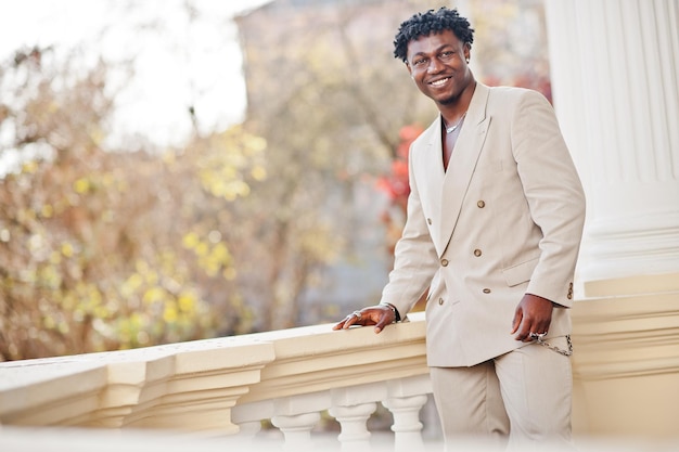 Elegante uomo afro in abito beige vecchia scuola giovane maschio africano alla moda in giacca casual sul torso nudo