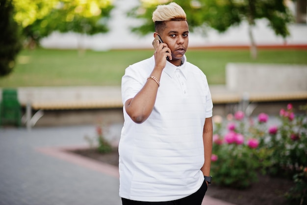 Stylish arabian muslim boy with originally hair posed on streets speaking on phone