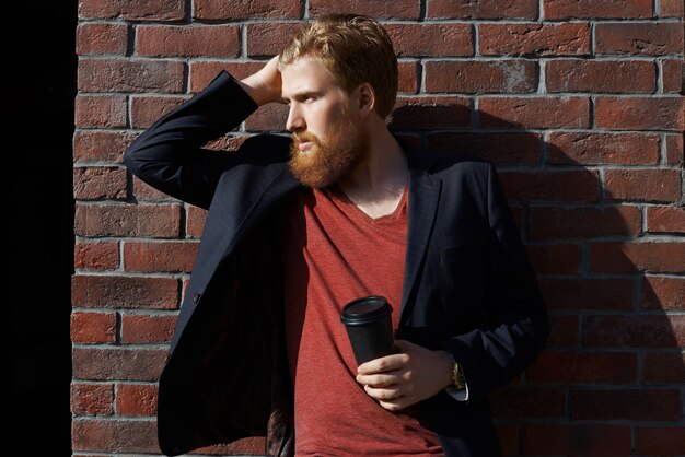 Stylish beard man drinks coffee