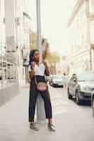 Free photo a stylish and beautiful dark-skinned girl sits in a cafe