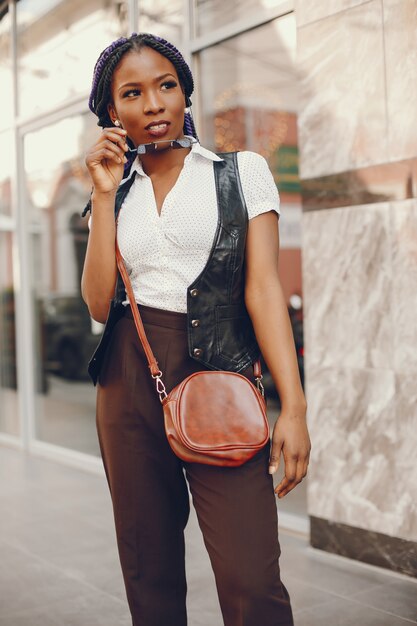 A stylish and beautiful dark-skinned girl sits in a cafe