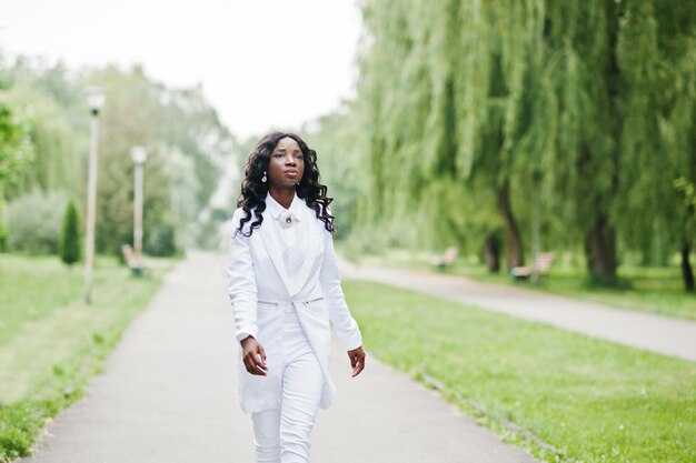 Free photo stylish black african american girl walking on road in park