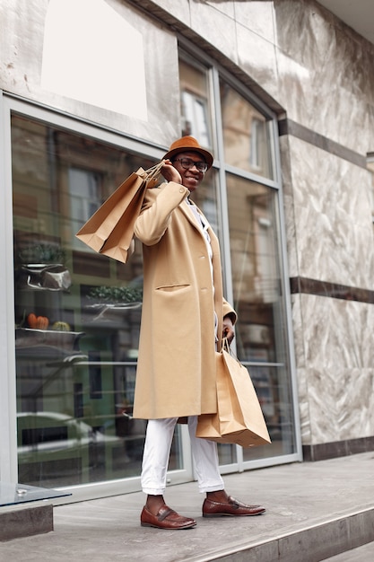 Stylish black man in a city with shopping bags