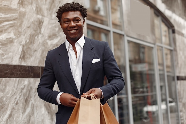 Free photo stylish black man in a city with shopping bags