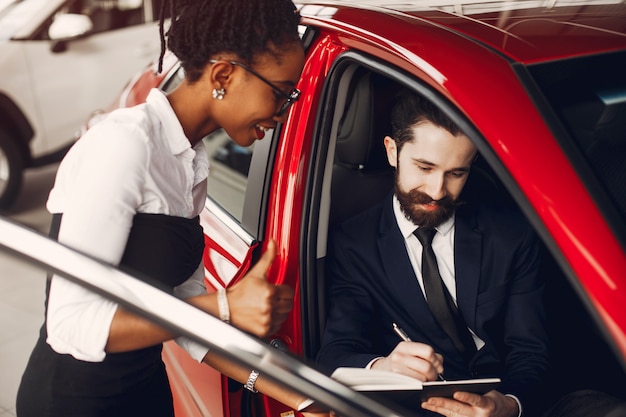 Elegante donna nera in un salone di auto