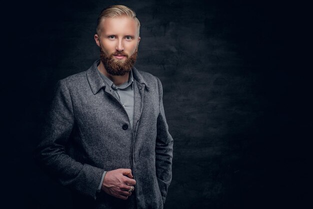 A stylish blond bearded male dressed in elegant, classic jacket.