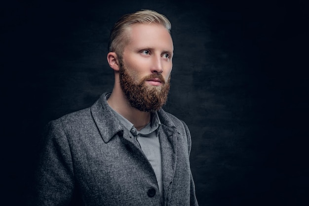 A stylish blond bearded male dressed in elegant, classic jacket.