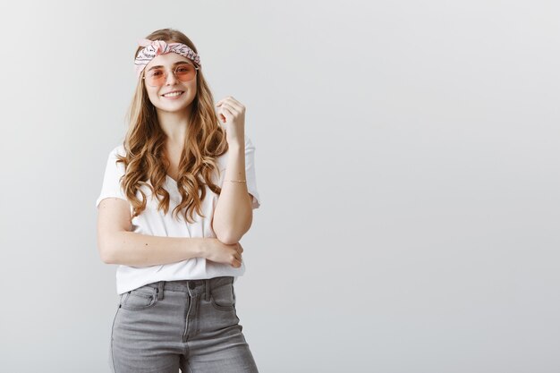 Stylish blond girl in sunglasses looking interested