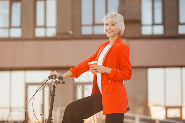 Stylish blonde woman posing with her bicycle