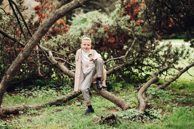 Stylish boy in a coat in autumn in the park autumn forest