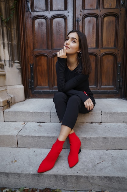 Free photo stylish brunette girl sitting on the stairs