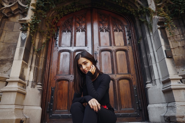 stylish brunette girl sitting on the stairs