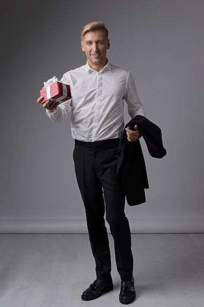 Stylish businessman holding gift box