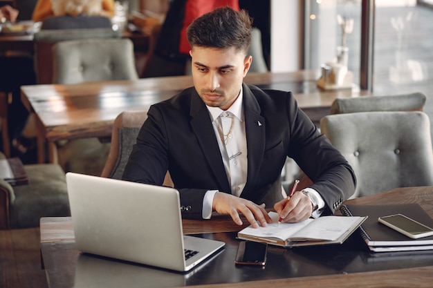 Stylish businessman working in a cafe and use the laptop