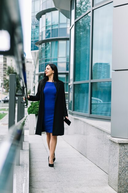 Stylish businesswoman walking outside building