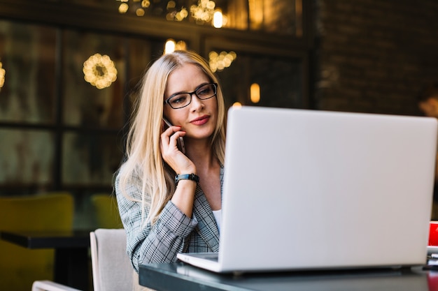 Free photo stylish businesswoman with laptop in cosy coffee shop