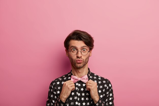 Free photo stylish caucasian man dresses new elegant bowtie, wears festive clothes for important meeting