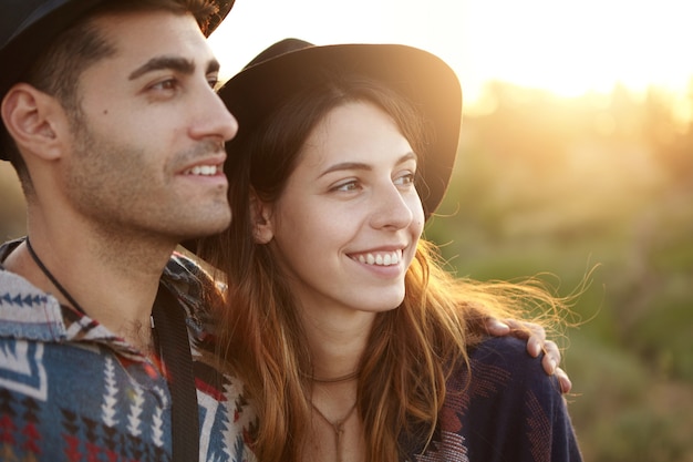 Stylish couple on field during sunset