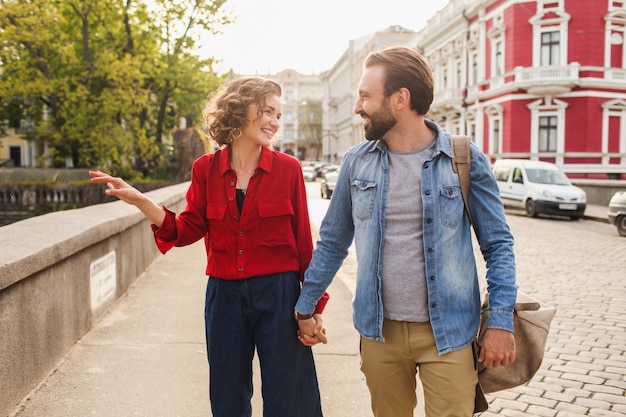 Stylish couple in love sitting in street on romantic trip