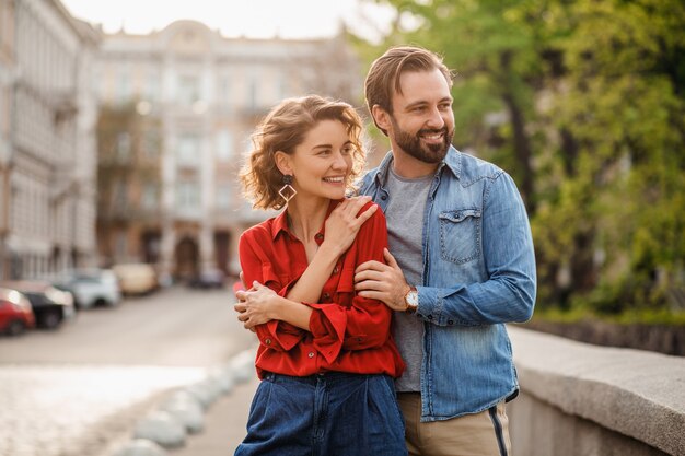 Stylish couple in love sitting in street on romantic trip