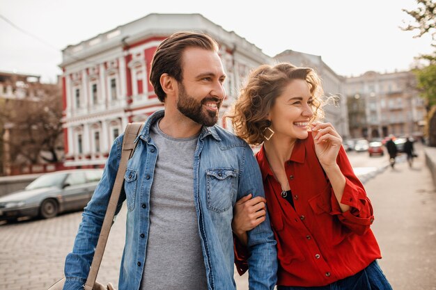 Stylish couple in love walking embracing in street on romantic trip