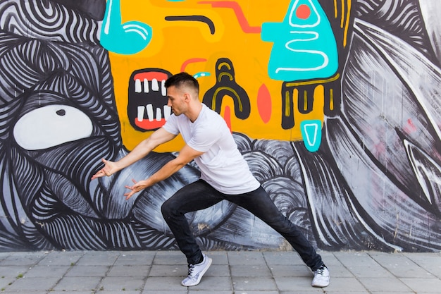 Stylish dancer against graffiti wall