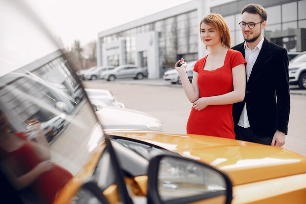 Stylish and elegant couple in car salon