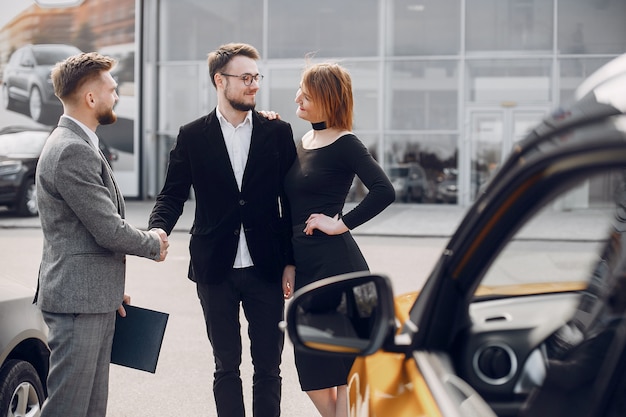 Free photo stylish and elegant couple in a car salon