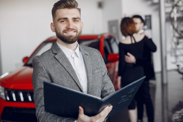 Stylish and elegant couple in a car salon