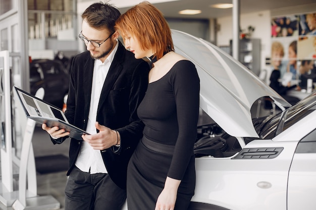 Stylish and elegant couple in a car salon