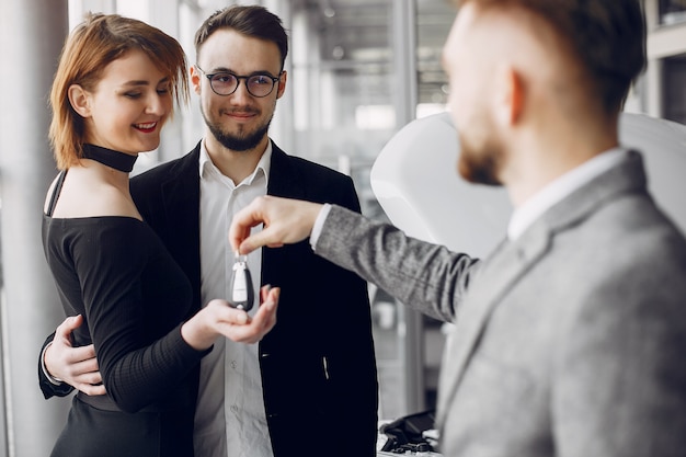 Foto gratuita coppia elegante ed elegante in un salone di auto