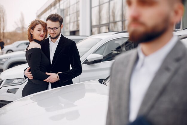 Stylish and elegant couple in a car salon