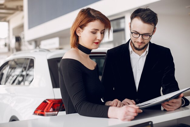 Stylish and elegant couple in a car salon