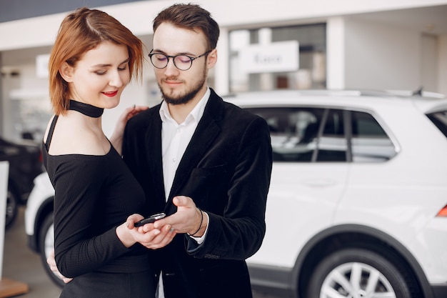 Stylish and elegant couple in a car salon