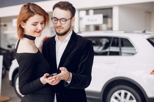 Stylish and elegant couple in a car salon