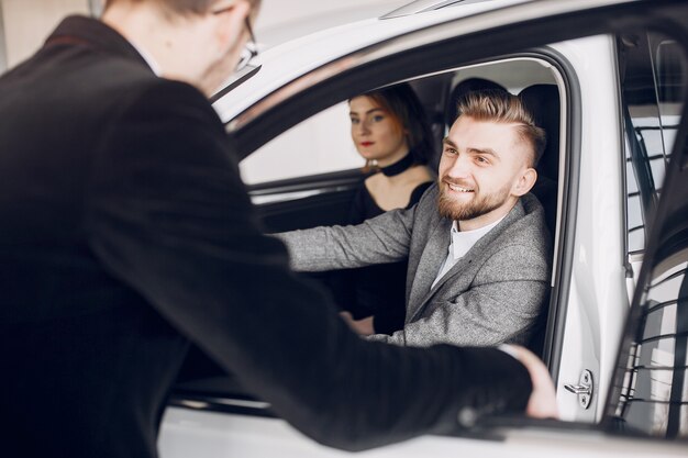 Stylish and elegant couple in a car salon