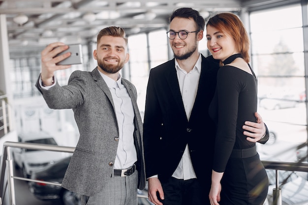 Stylish and elegant couple in a car salon