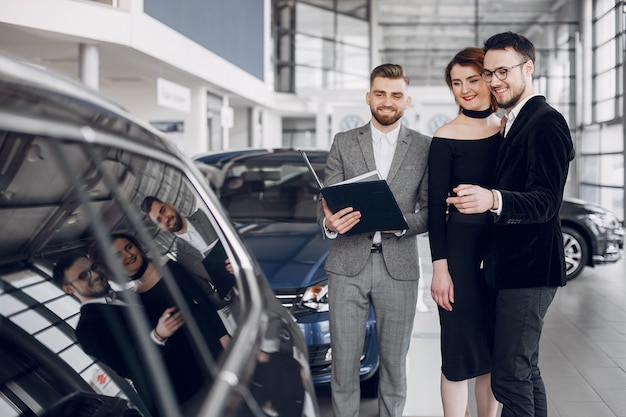 Stylish and elegant couple in a car salon