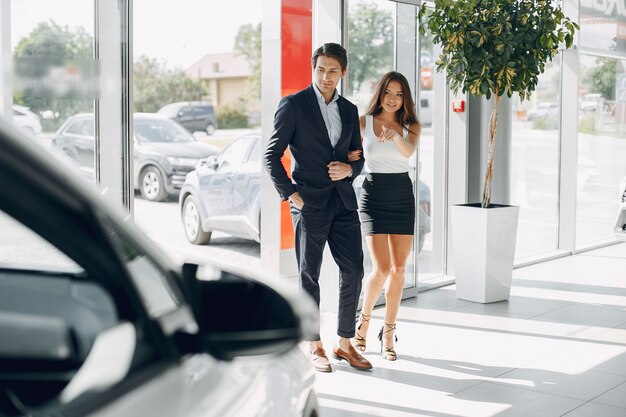 Stylish and elegant couple in a car salon