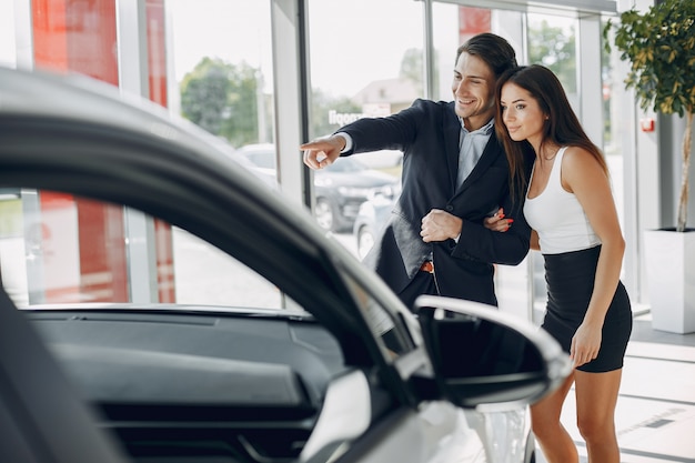 Stylish and elegant couple in a car salon