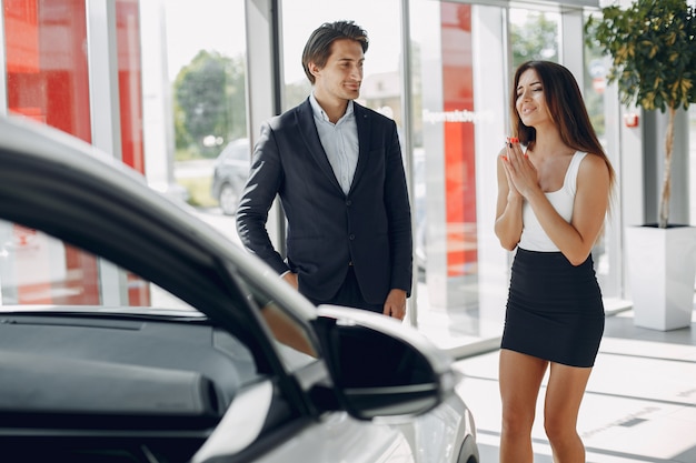 Stylish and elegant couple in a car salon