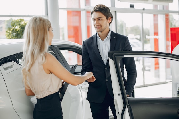 Free photo stylish and elegant couple in a car salon