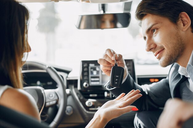 Stylish and elegant couple in a car salon