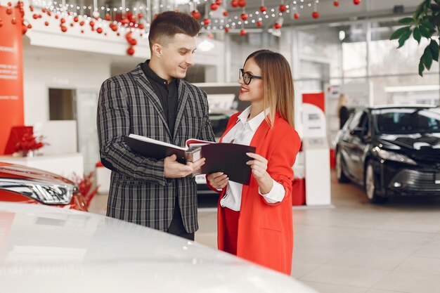 Stylish and elegant couple in a car salon